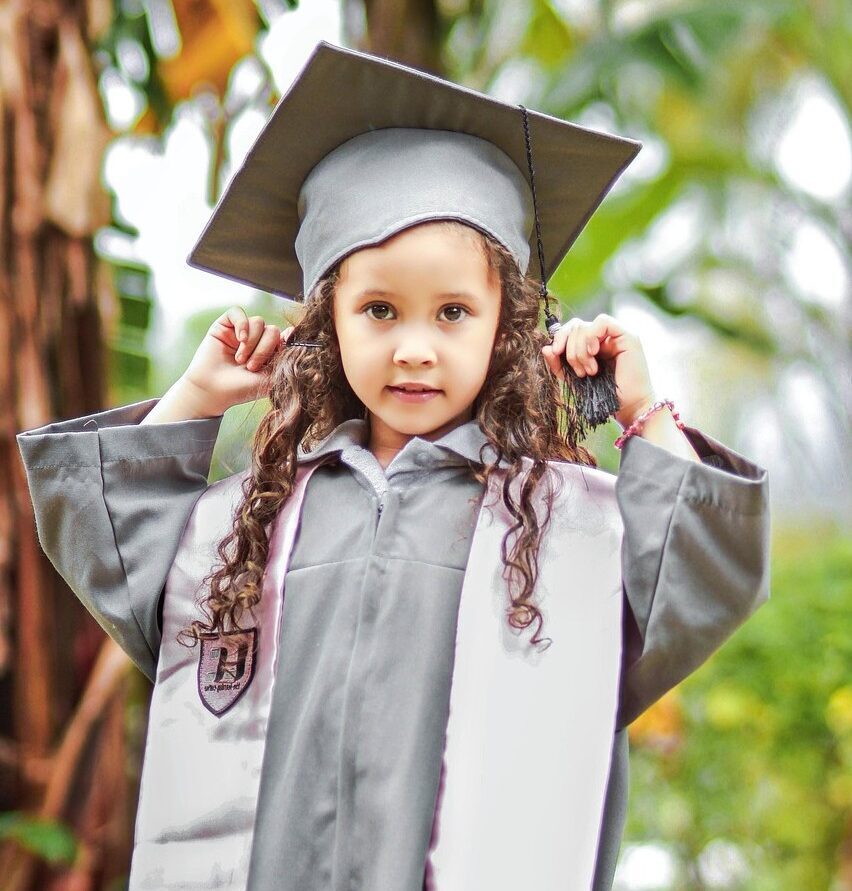 Mädchen mit Abschlussrobe und -hut